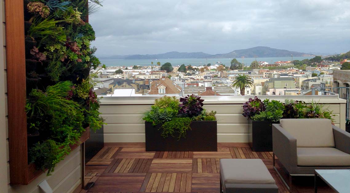 rooftop terrace featuring living wall, seating, and view of San Francisco marina