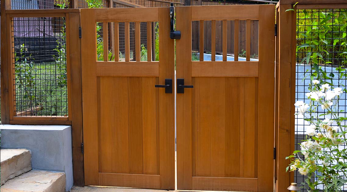 Elegant outdoor wooden double doors and fencing around pool area