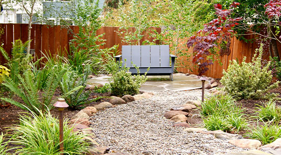 well-maintained back yard with curving stone-lined pathway