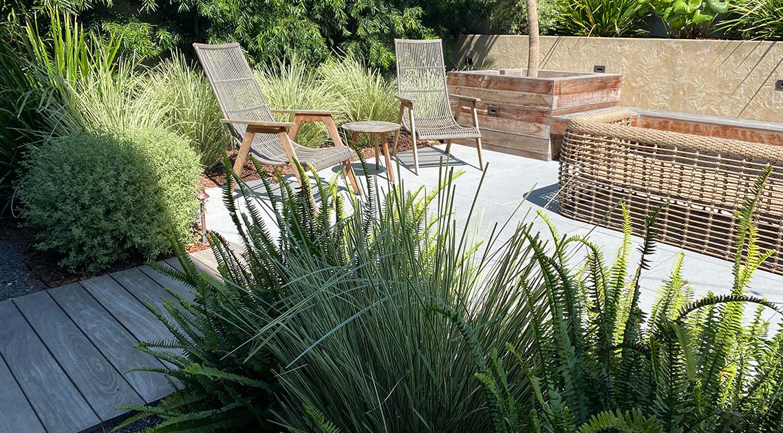 paved back yard with outdoor furniture and plants