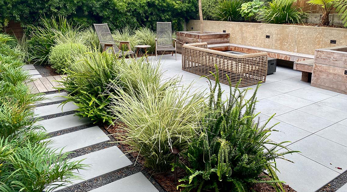 paved back yard with stepping stones, outdoor furniture and plants